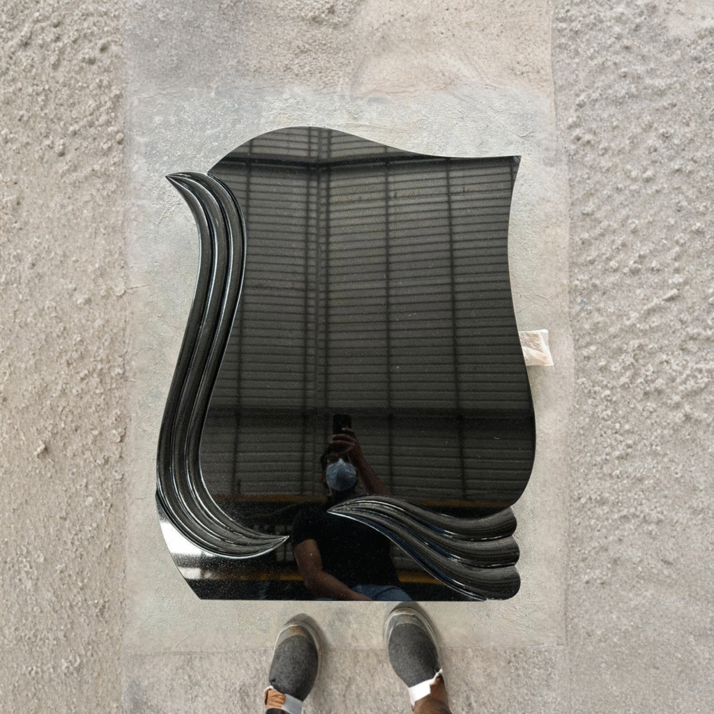 Flawless, high-polished black granite upright headstone featuring a modern, multi-layered carved wave and fluted edge design along the left and bottom contours