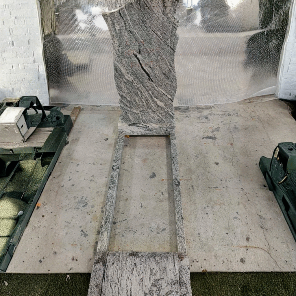 High-polished Viscon White granite headstone with natural wave patterns and rustic rock-pitch edges, featuring a matching full-length memorial kerb set.