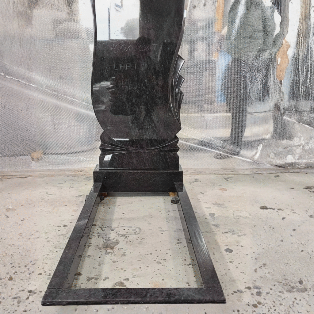 High-polished dark granite upright headstone featuring a modern wave design with elegant scalloped side edges, complete with a matching memorial kerb set and base